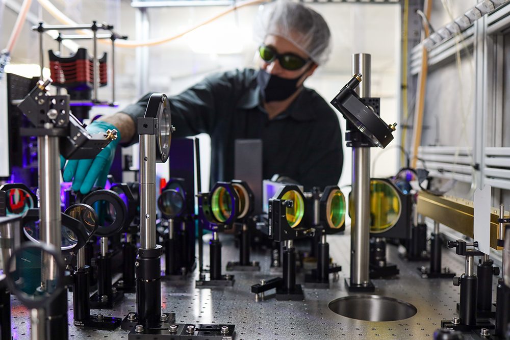 Seurat Technologies Employee sets up a series of lenses for lasers to flow through.